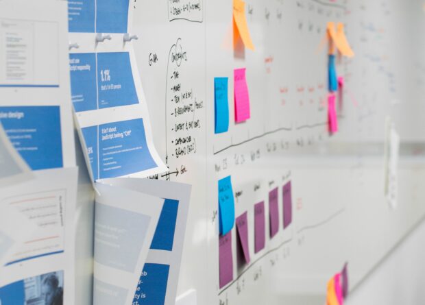 A white board with colourful post-it notes on