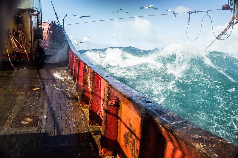 Fishing boat crashing through rough waves