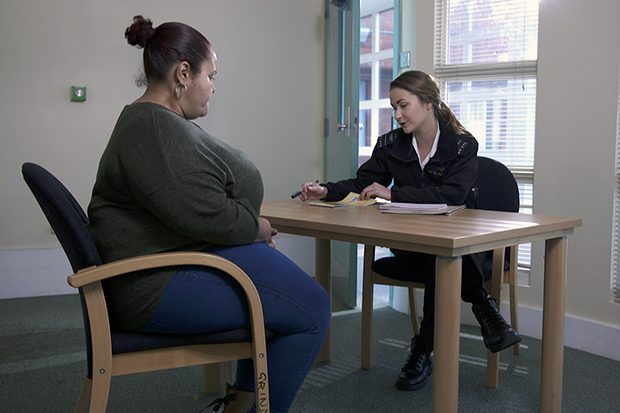 An image from one of the self-selection tool videos of an actor ex-offender speaking with a prison officer