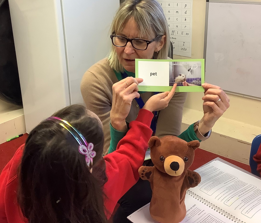 A woman showing a student a piece of paper