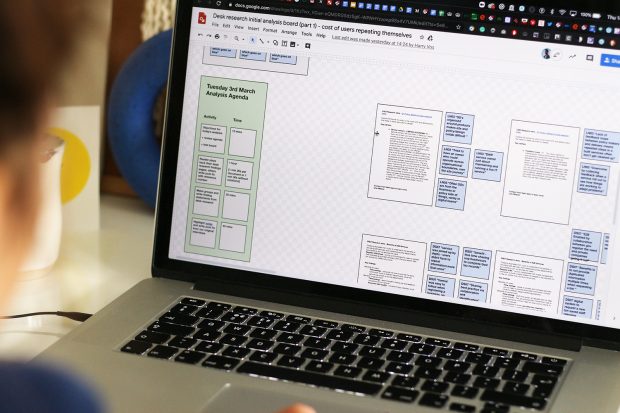 A laptop screen showing desk research into the cost of users repeating themselves