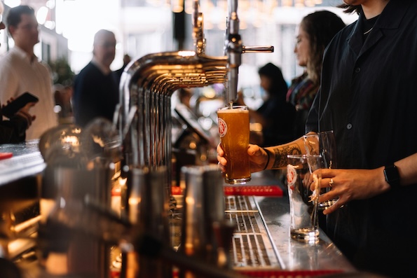 A man pours drinks at a bar
