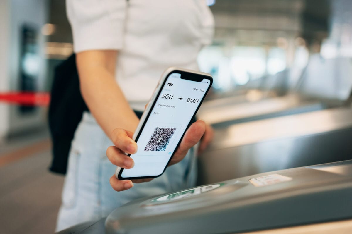 A person using a smart phone to scan their ticket at a train station