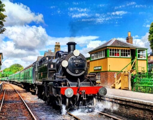 A train departing Alresford station on the Watercress Line