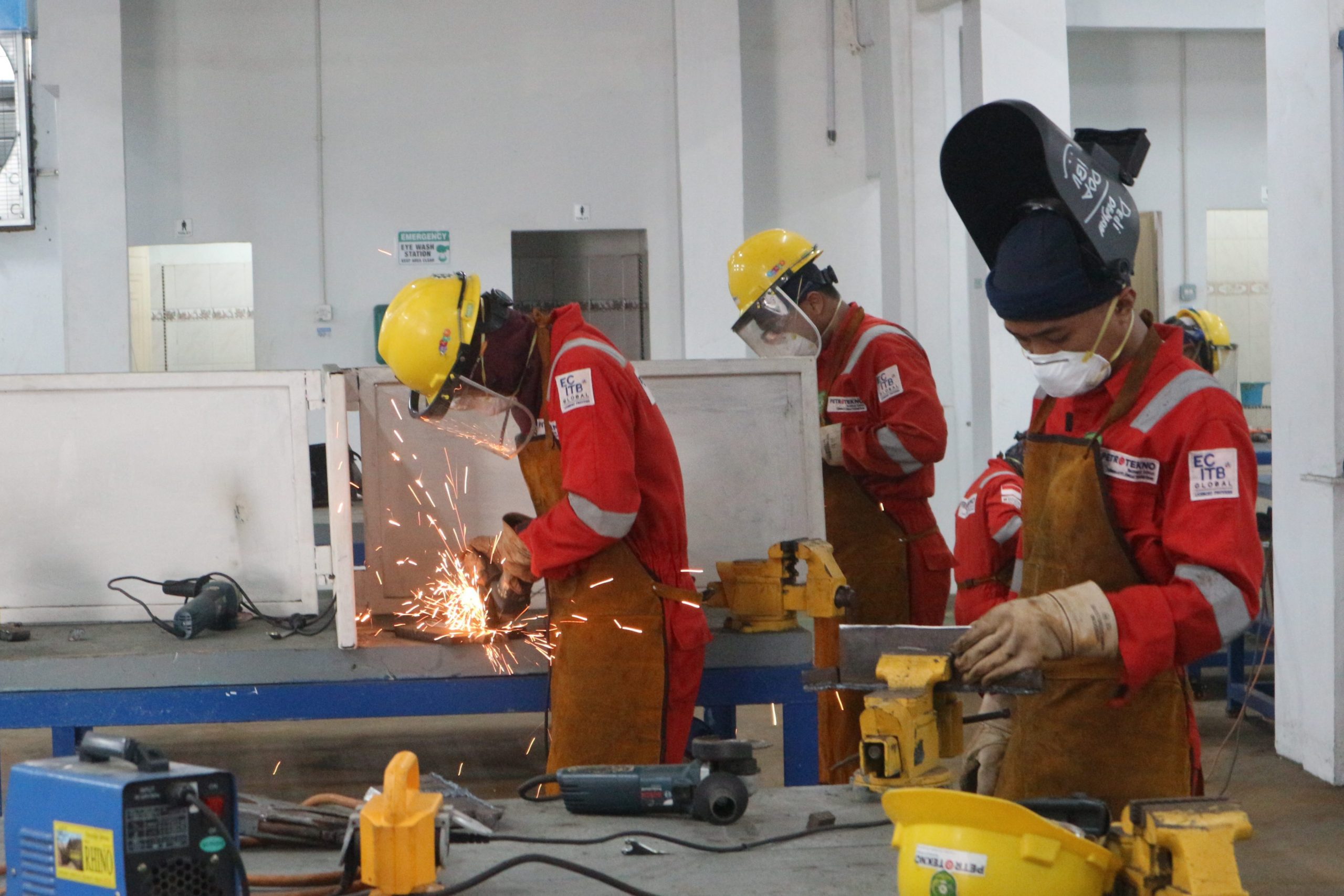 Engineers wearing orange jumpsuits welding in Batam, Indonesia