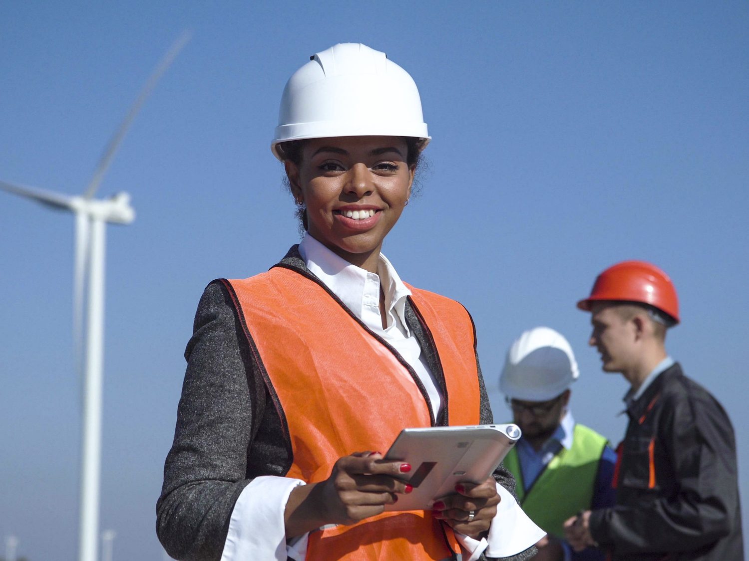 Woman With hard hat Against Wind Turbine