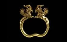 Gold armlet with two dragon looking figures attached. 