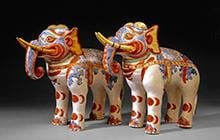 Two red, white, blue and gold decorated mantelpiece elephants figures.