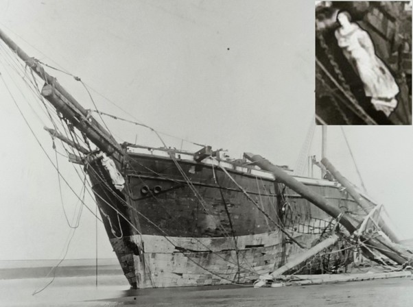Historic black and white photograph of the Vanadis, seen in port bow view with her masts having collapsed over the side. An inset at top right shows the detail of the figurehead from the same photograph. 