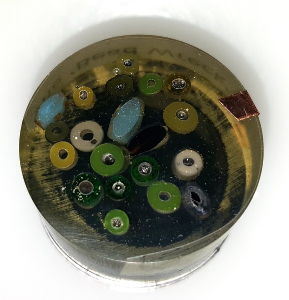 Beads dotted around in a circular resin mount.