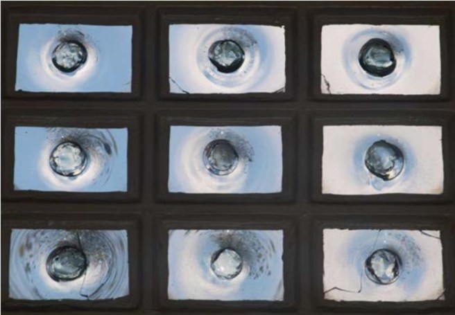 Nine bull's eye panes individually set in a dark multi-pane frame.