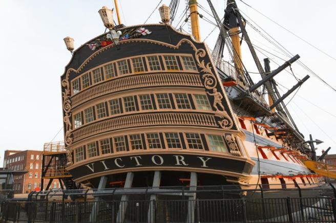 Three tiers of stern windows picked out in black and gold over the name VICTORY .