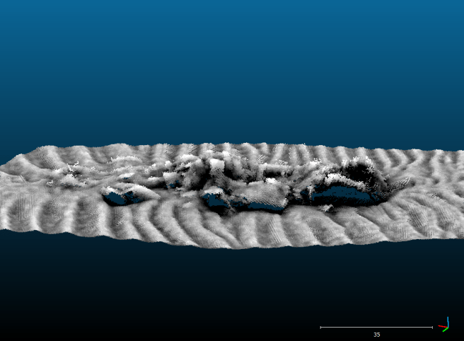 Computer-generated image of the wreck site on the seabed, showing a jumbled mass of darker metal in grey against a grey background of sandwaves.