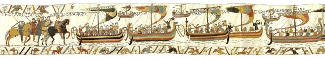 Multicoloured tapestry scenes of ships laden with men and horses, with horsemen waiting at the left side of the scene, embroidered on a cream background, with border decoration in the lower register, and at top left.