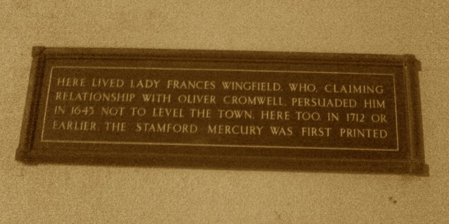 Sepia photograph of dark plaque, with text commemorating Lady Francis Wingfield and the founding of the Stamford Mercury, associated with the same building.
