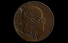 A penny with the words "votes for women" defaced across the Kings head.