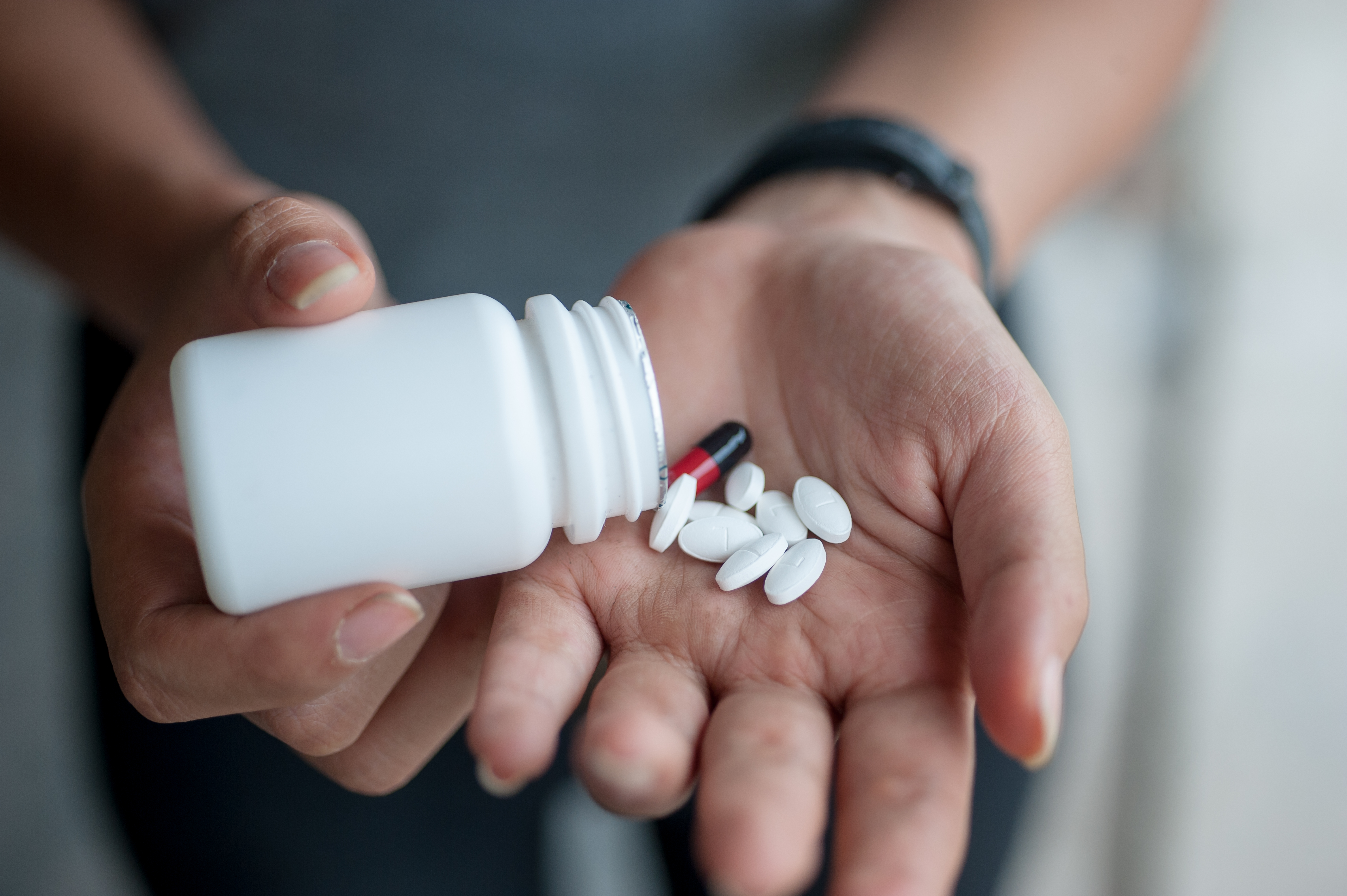 Person pouring medication into their hand