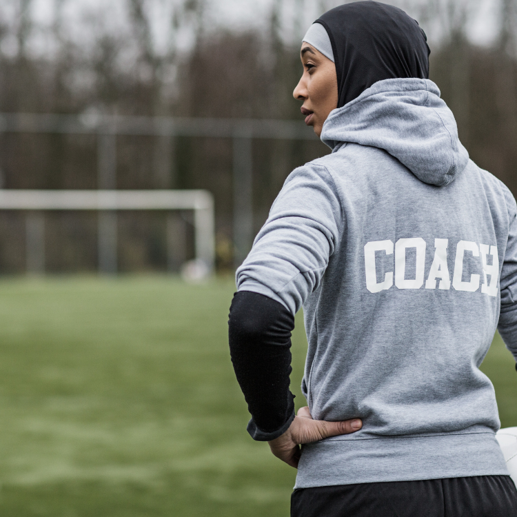 A coach standing at the side of a pitch