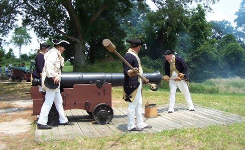Four men load a cannon.