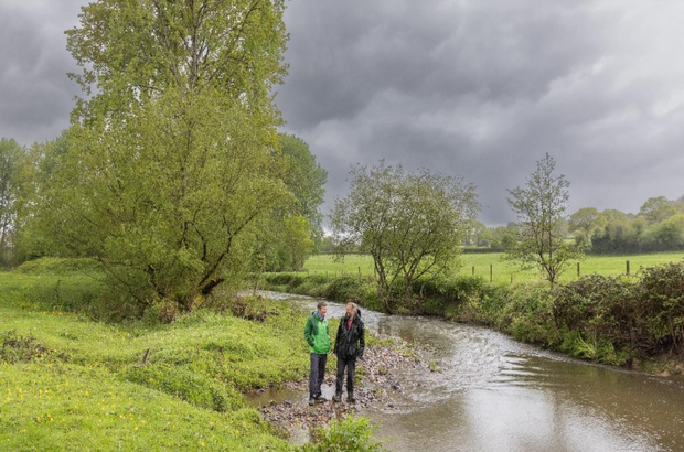 Axe Landscape with two men standing on bank of river