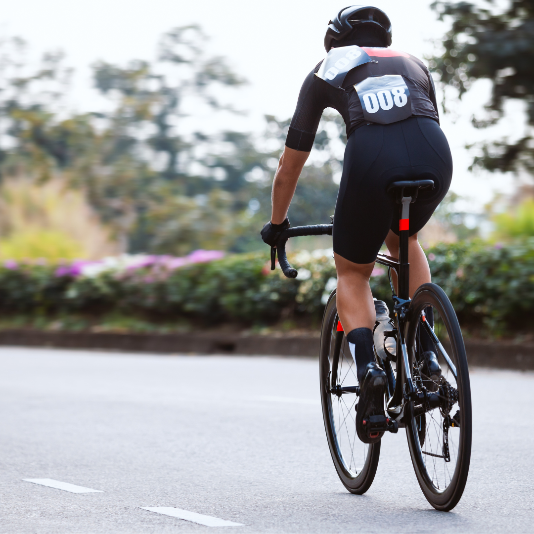 Person cycling on a road, photo taken from behind