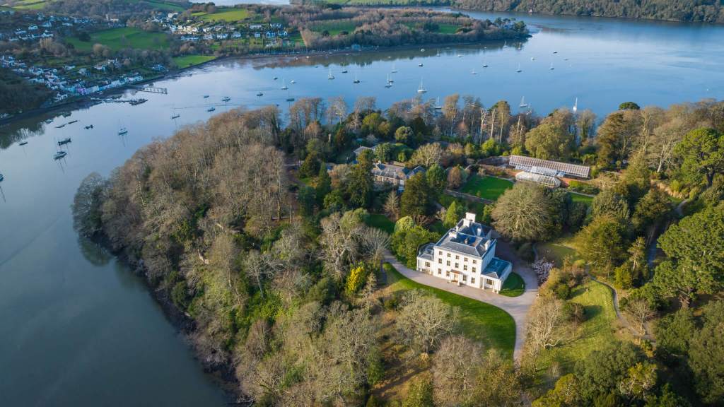 An aerial photograph of a country house and grounds situated next to a river.