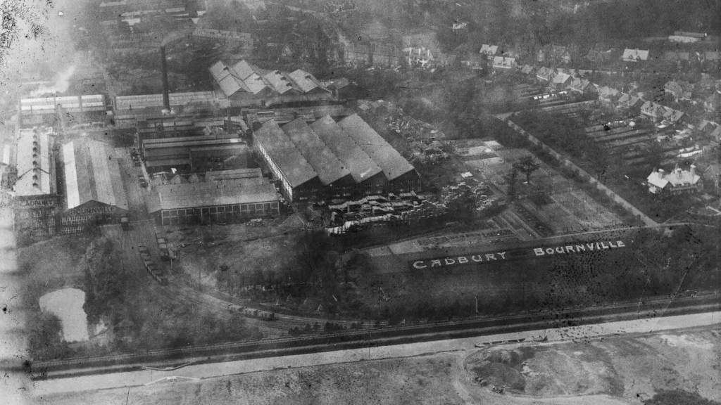 A black and white archive aerial photograph of a factory complex with large white letters spelling out "Cadbury Bournville".