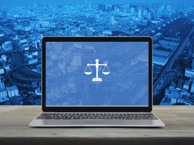 Law flat icon with modern laptop computer on wooden table over city tower, street, expressway and skyscraper, Business legal service online concept