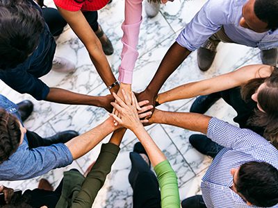 Workspace: Team Of Diverse Workers Put Hands Together