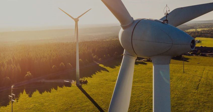 Disciplines   An Aerial View Of A Wind Turbine In The Middle Of A Green Field