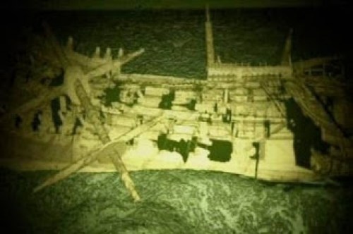 A CGI reconstruction of the wreck of a wooden vessel lying on her side with holes blown in her structure.