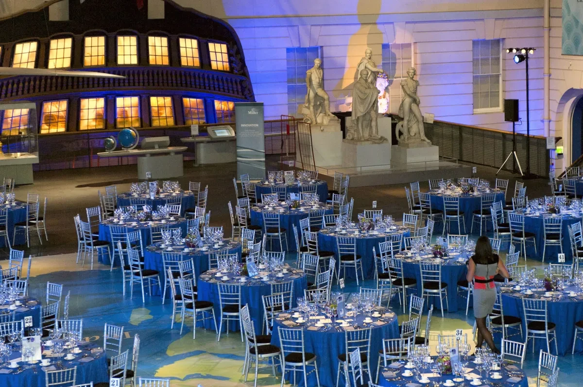 A number of round tables and chairs have been dressed ready for an event.