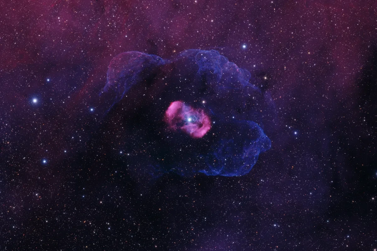 Bright star surrounded by rich purple, indigo and blue nebulae