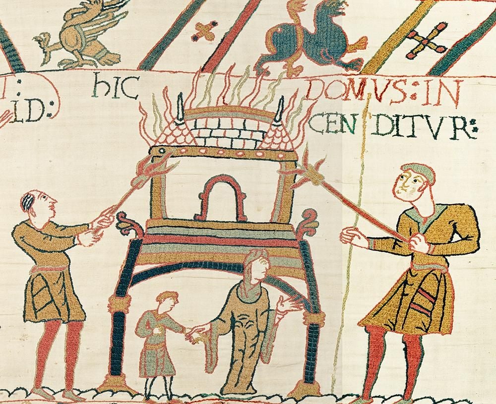 A section of the Bayeux Tapestry showing two men setting a building alight as a woman and child flee.