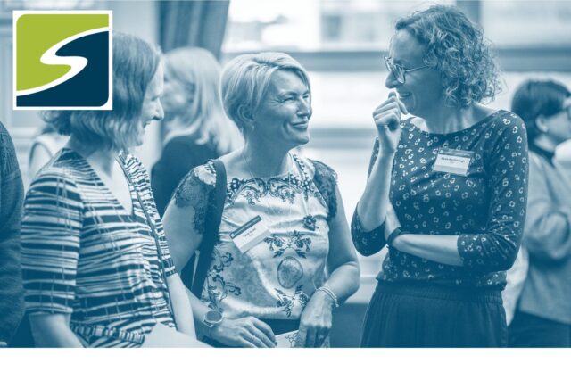 three people stood in a half circle talking at the GSS conference