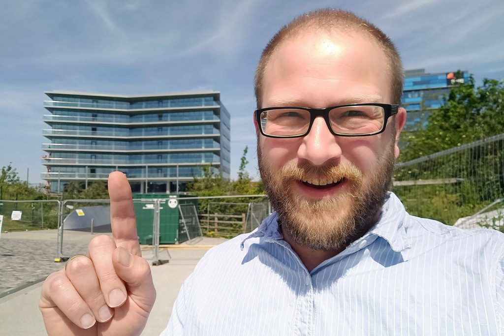 Ben Conrad standing outside and pointing to the new Bristol Regional Centre