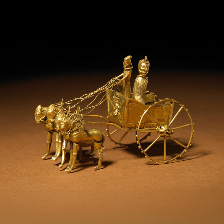 Model of gold chariot drawn by four horses abreast, with a driver and a figure wearing a long robe in the cab