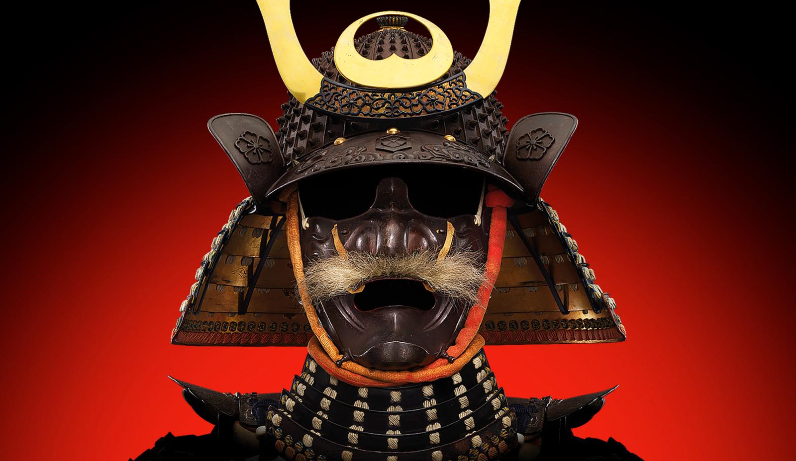 A samurai helmet with gold-coloured horns and a metal face mask with a moustache made of a fur-like material.