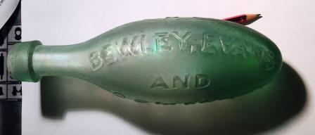 Green bottle with moulded lettering reading BEWLEY EVANS AND visible, against a white background.
