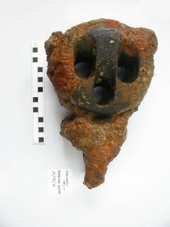 Deadeye with rust-coloured concreted surface, label and scale rule to left