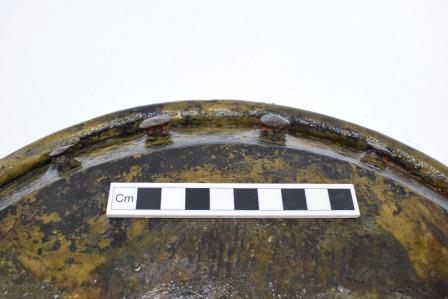 Detail of 4 rivets on rim of pan, with centimetre scale