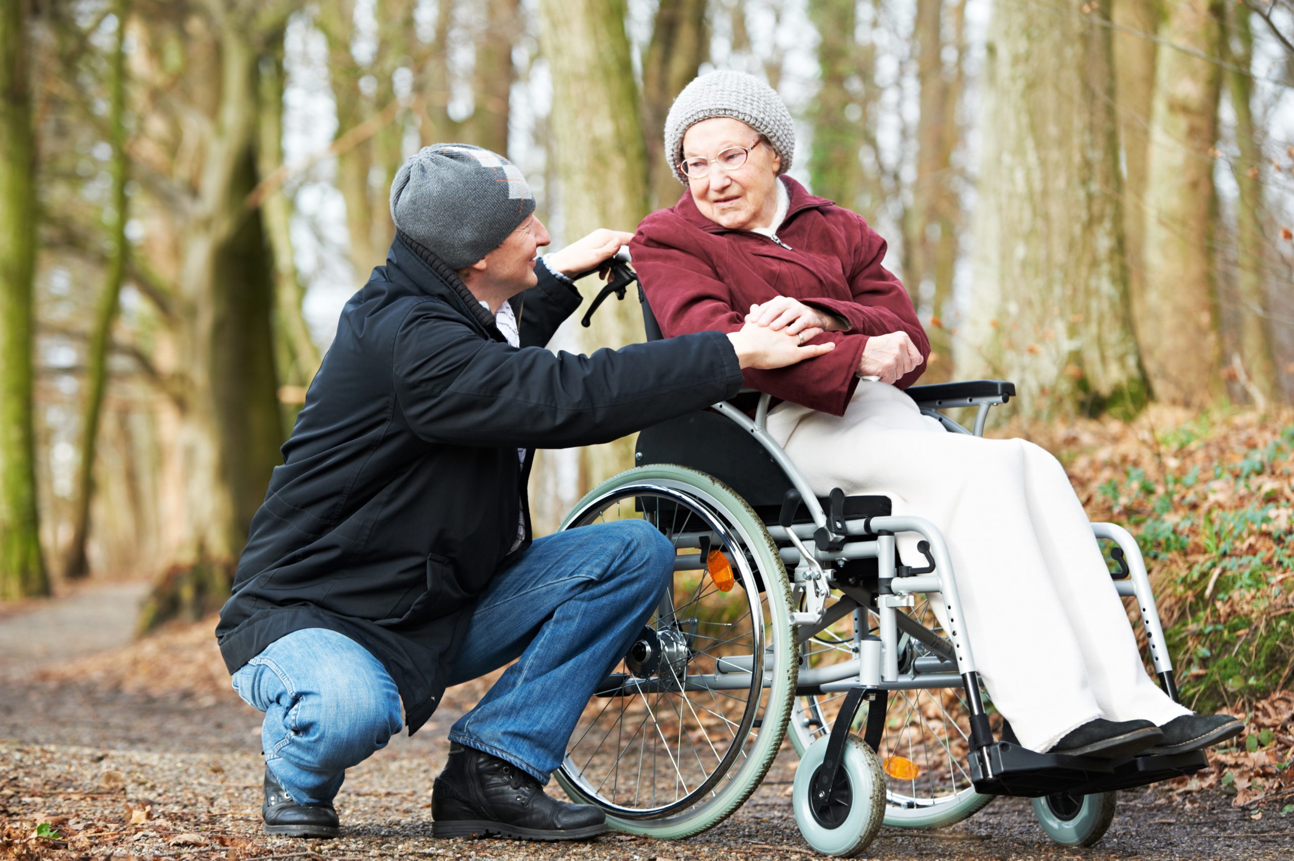 Woman in a wheel chair talking to her carer in the countryside