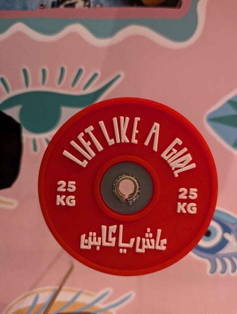 25kg weight with text on it in english and arabic reading 'lift like a girl'