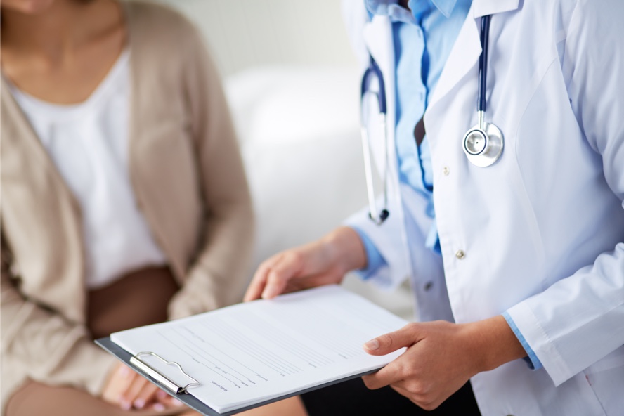 Doctor holding a notepad while talking to patient