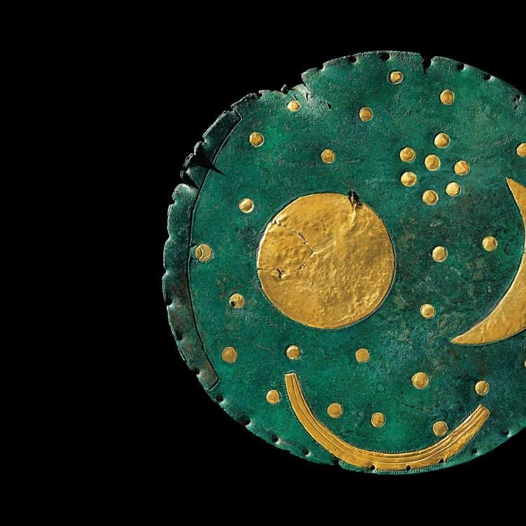 A round blue disc with circle and crescent moon shapes on it. 
