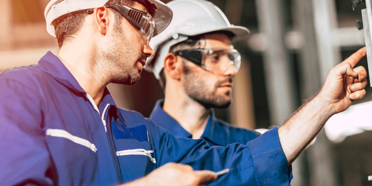 Training standards - Two Men In PPE Looking Inspecting Equipment