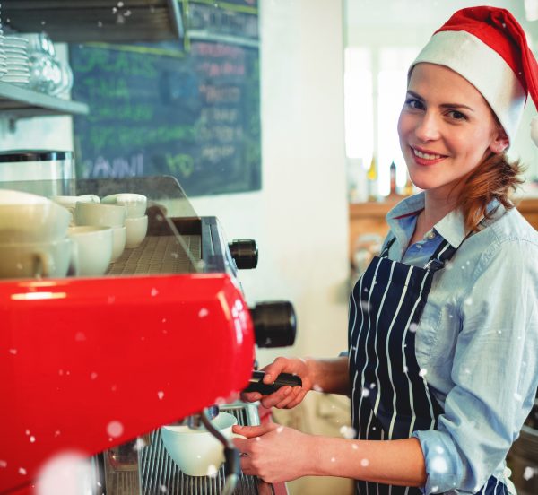 Woman wearing a santa had making coffee in a cafe