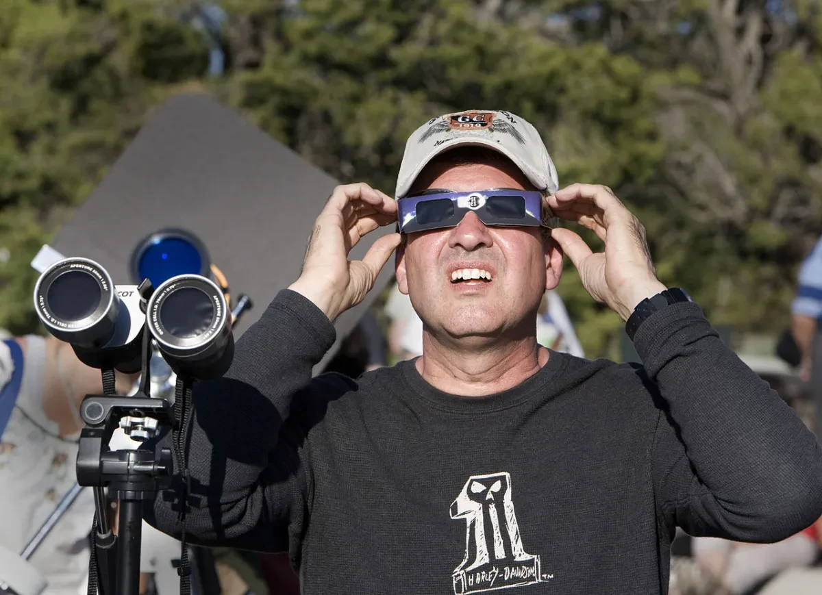 A man wearing special glasses to view a solar eclipse.
