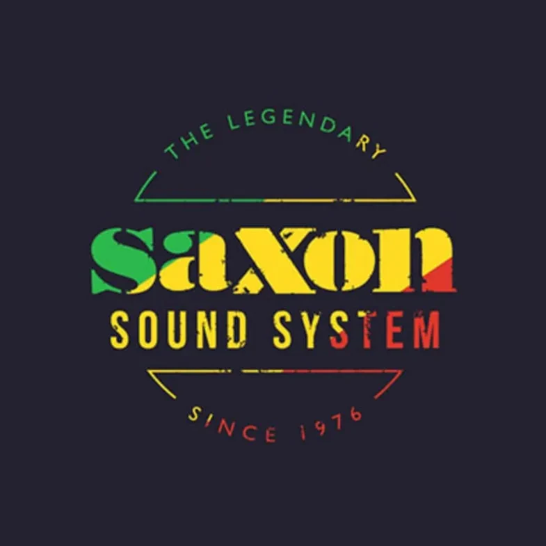 Logo for The Legendary Saxon Sound System. The design features the words "The Legendary" above bold "Saxon" lettering in green, yellow and red, with "Sound System" below in yellow. Curved lines frame the design above and below, and the words "Since 1976" appear at the bottom.