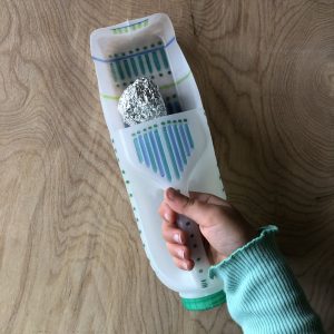 Person holding carton with foil ball inside